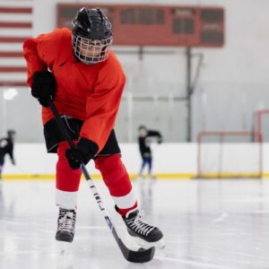 Ice hockey player with stick on rink